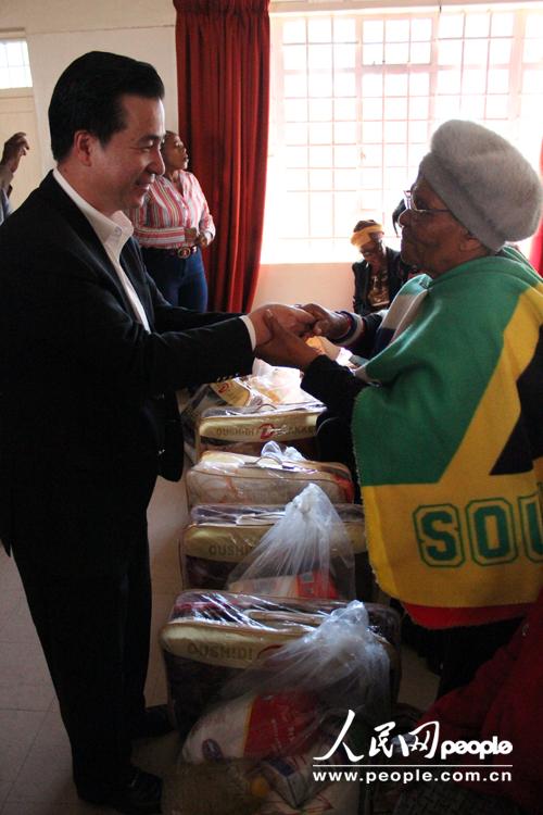 南部非洲中华福建同乡总会会长杨天峙在向自由州省贫困地区民众颁发生活用品。（依拉 摄）