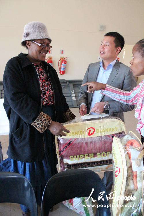 自由州省福建同乡会会长石欣平在向贫困老人捐赠生活用品。（依拉 摄）

